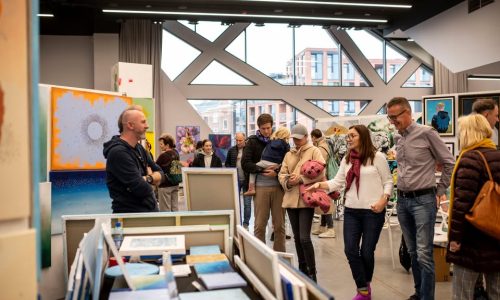 18 lat tradycji, sztuki i designu Targowisko Sztuki to jedno z najdłużej działających wydarzeń artystycznych w Polsce, które od osiemnastu lat łączy artystów i miłośników sztuki. Tworzymy wyjątkową przestrzeń, gdzie można nie tylko podziwiać, ale i kupować dzieła bezpośrednio od twórców. Prezentujemy malarstwo, grafikę, fotografię, rzeźbę, plakat, ceramikę i design, dbając o różnorodność stylów, technik i form. To wydarzenie dla każdego, kto ceni sztukę – zarówno dla kolekcjonerów, dekoratorów wnętrz, jak i osób, które szukają unikalnych prac do swojego domu lub biura. Targowisko Sztuki to również idealne miejsce dla artystów, którzy chcą zaprezentować swoją twórczość szerszej publiczności, nawiązać kontakty i bezpośrednio sprzedawać swoje prace. Stawiamy na wysoką jakość i staranną selekcję wystawców, dlatego każda edycja gromadzi wyłącznie najlepszych twórców z różnych dziedzin sztuki. Wyróżnia nas także wyjątkowa atmosfera – bezpośrednie spotkania z artystami, inspirujące rozmowy i możliwość odkrywania nowych talentów sprawiają, że Targowisko Sztuki to coś więcej niż zwykłe targi. Zapraszamy wszystkich, którzy kochają sztukę i chcą otaczać się oryginalnymi, niepowtarzalnymi pracami.